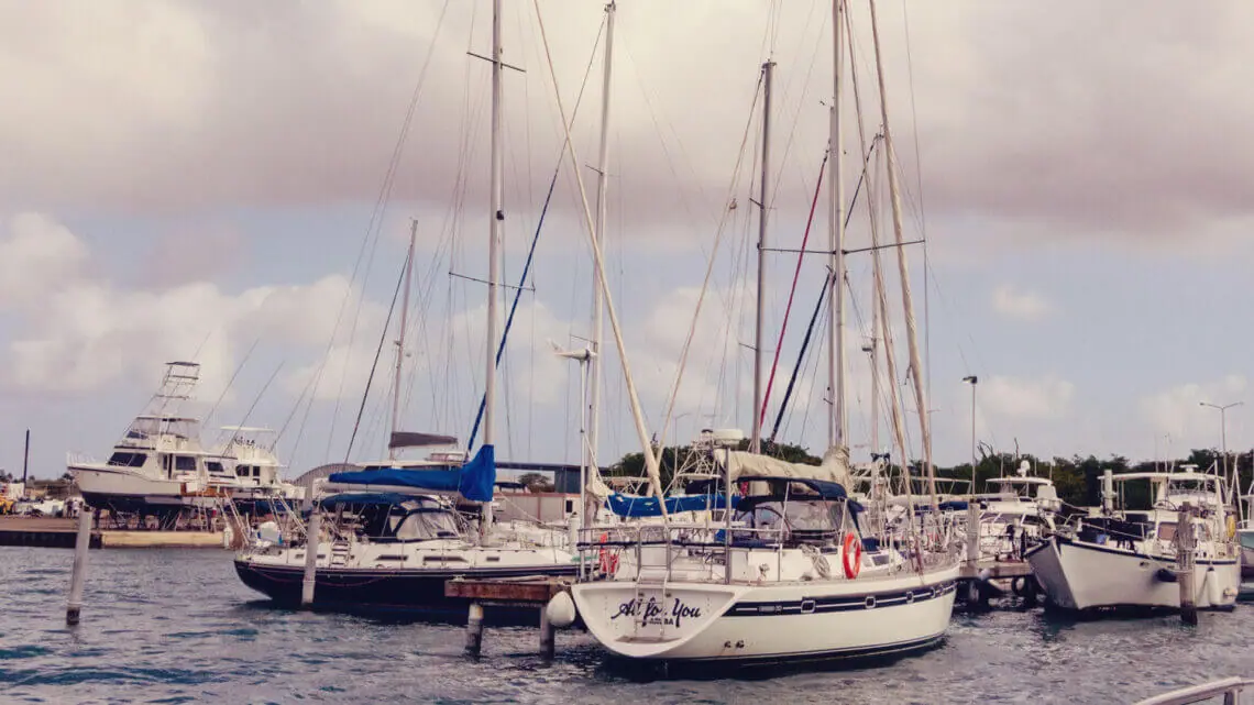 Aruba: Qual moeda levar? Imagem de barcos em um pequeno porto em praia de Aruba