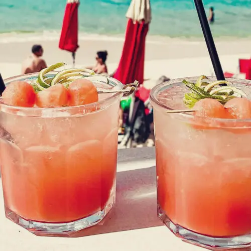 Dois drinks na praia de Saint Martin. Acompanhe no texto as 12 comidas típicas de Saint Martin