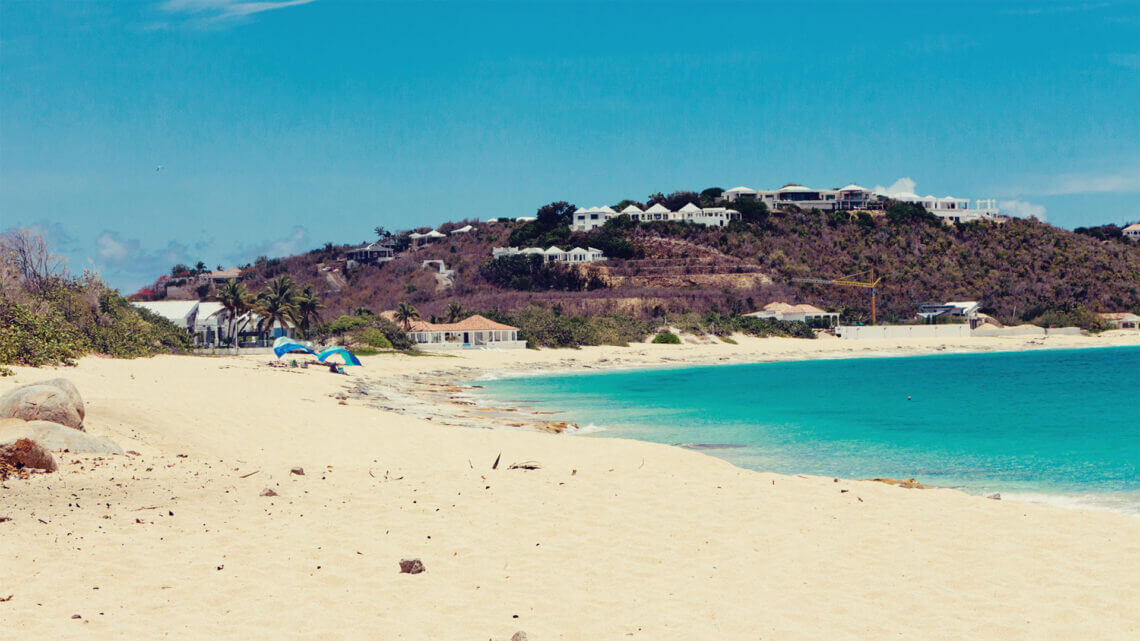 Praia em Saint Martin com areia branca e céu azul.  