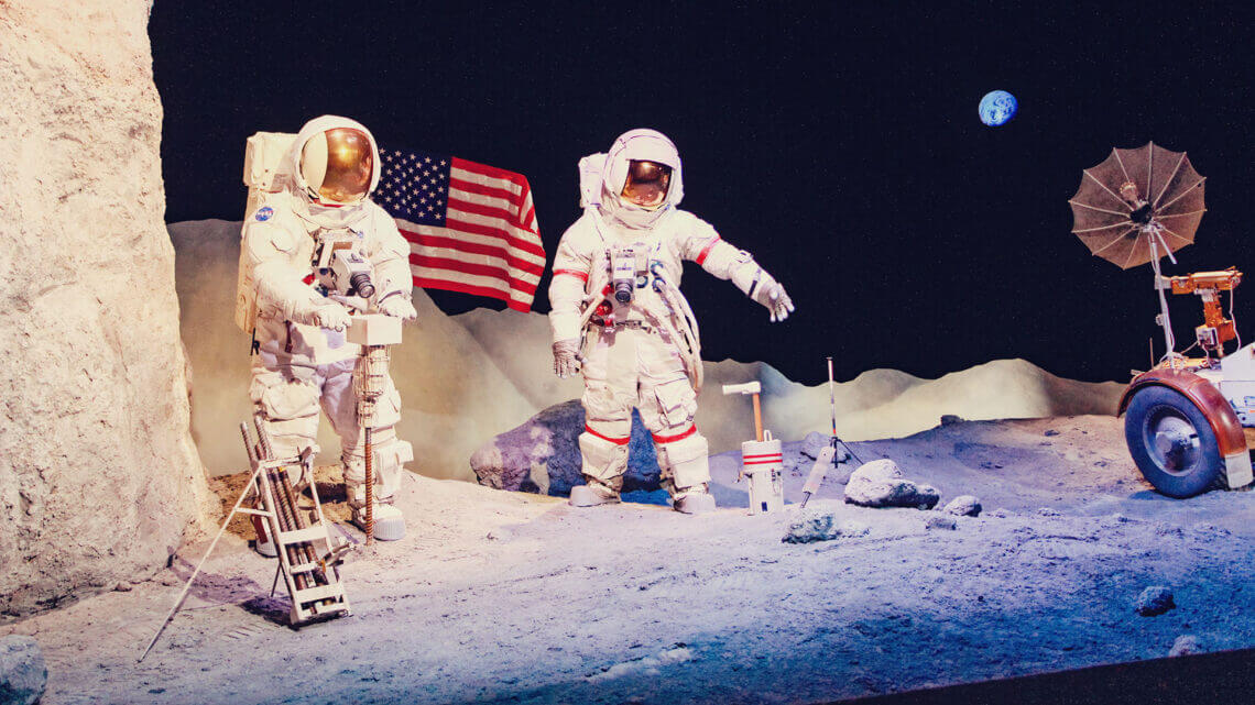 Dois astronautas na lua em exposição. Descubra o que é turismo espacial