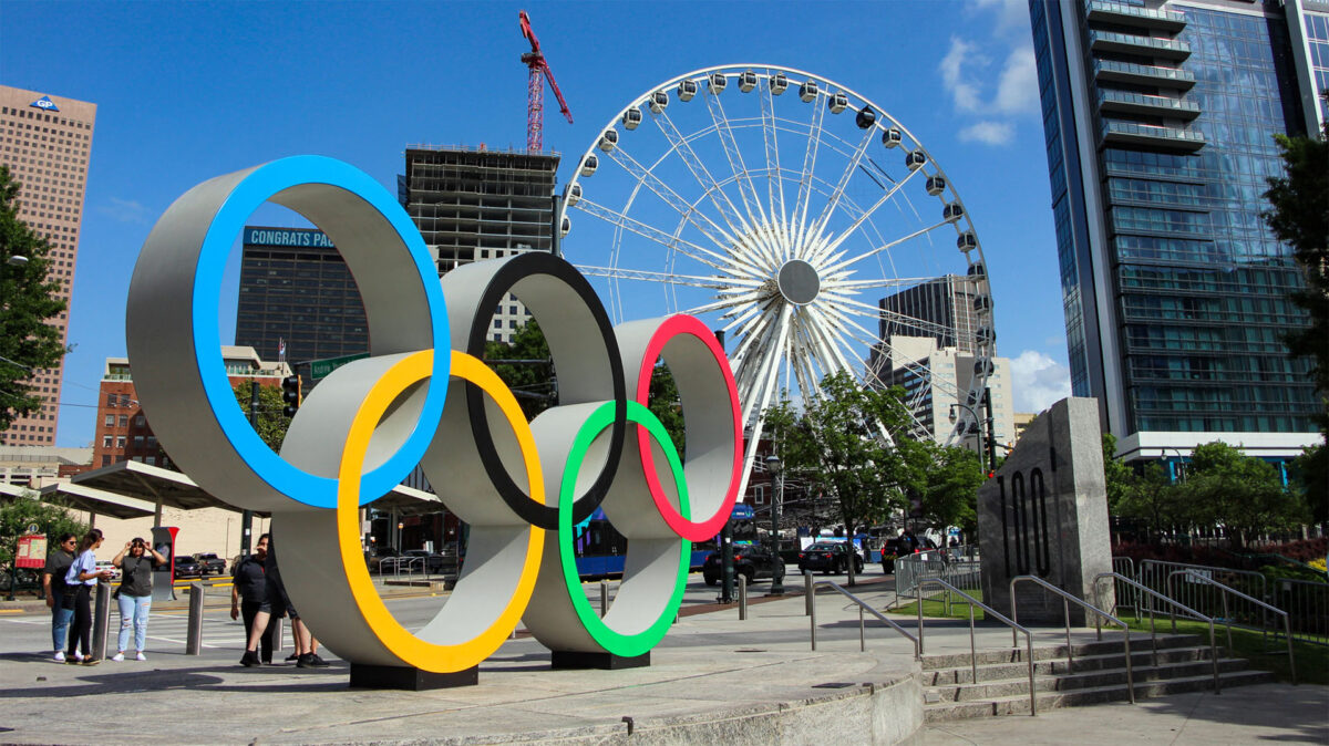 Círculos olímpicos à frente da roda gigante Sky View Atlanta, no parque Centennial Olympic Park