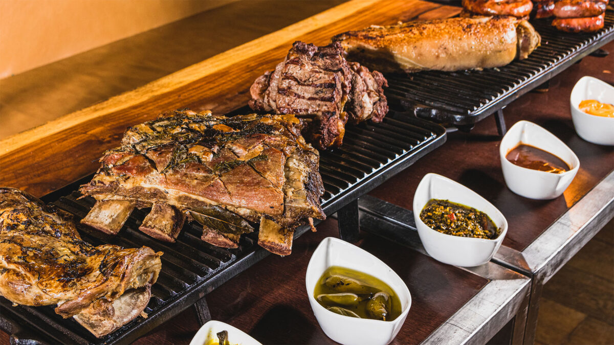 Mesa com grelha aquecendo cinco tipos de carne com potes de molho para acompanhar a carne no brunch de natal do Hotel Grand Hyatt