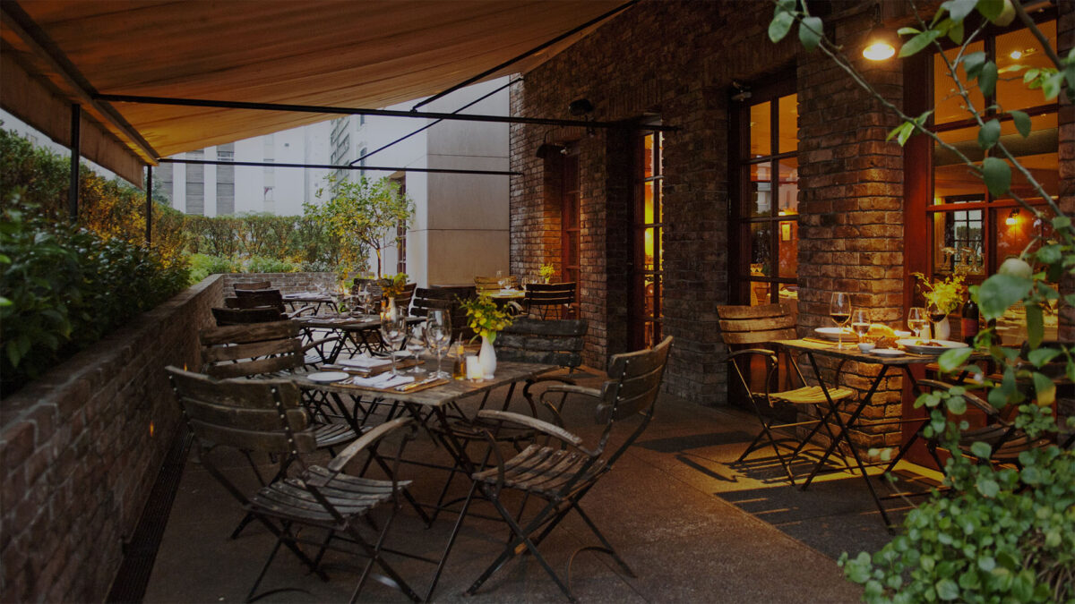 área das mesas externas de madeira do restaurante Nonno Ruggero, onde será servido o brunch de natal do hotel Fasano Jardins
