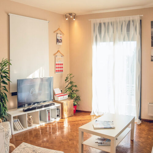 Sala de estar mobiliada em tons claros com luz do sol entrando pela janela. Se você pretente se hospedar em um Airbnb, confira as novas regulamentações da plataforma pelo mundo