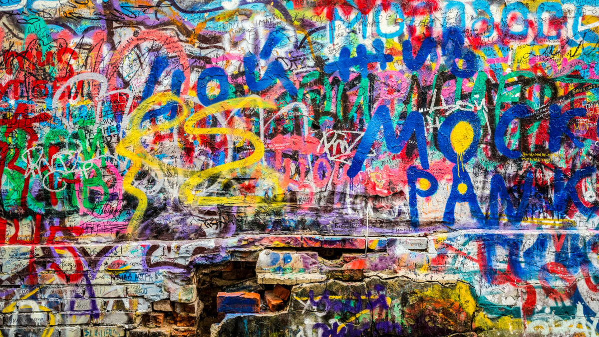 Parede com várias mensagens coloridas sobrepostas. Com a arte urbana em Berlim as paredes transmitem expressões dos artistas. 