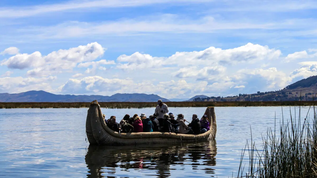 Pessoas em um barco no lago Titicaca, na fronteira entre o Peru e a Bolívia, na Cordilheira dos Andes em dia ensolarado.