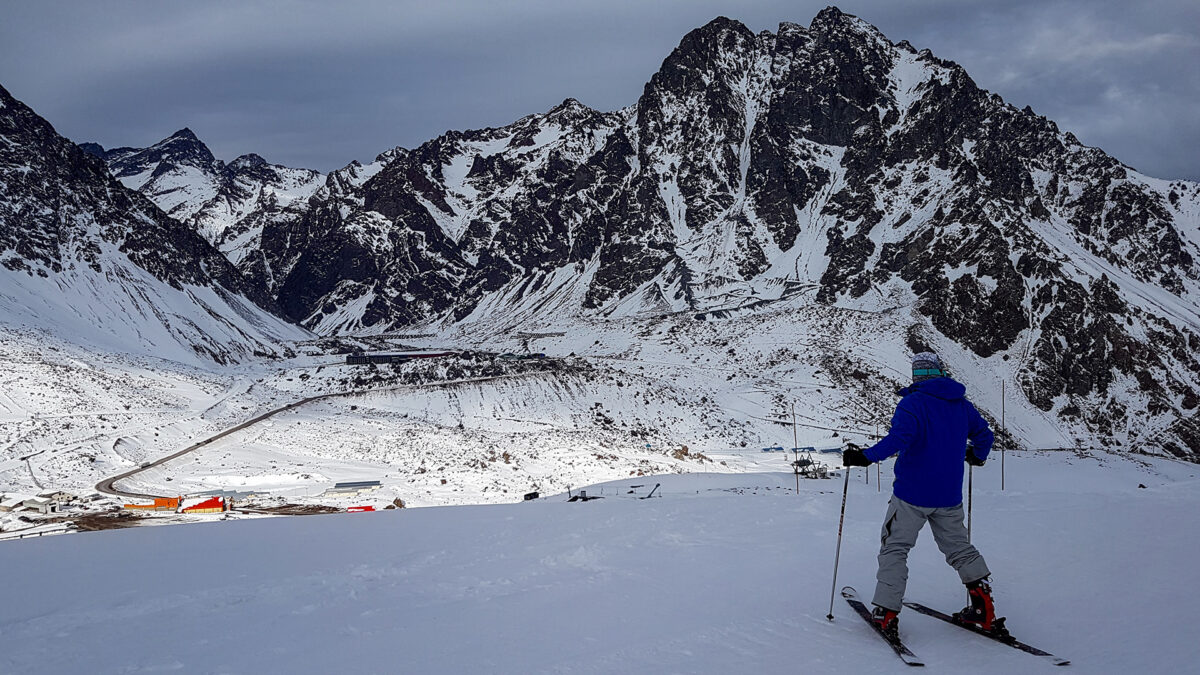 Portillo 2026: guia da estação de esqui mais antiga da América do Sul 9 Esquiador descendo pista com a cordilheira dos Andes ao fundo - pistas de esqui portillo